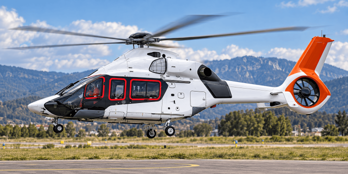 Airbus H160 helicopter with orange tail and red window trim hovering above an airfield, illustrating the Airbus H160 safety directive.