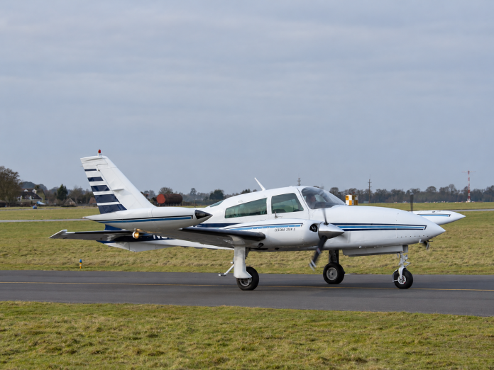 Cessna 310R twin engine aircraft taxiing on an airport runway